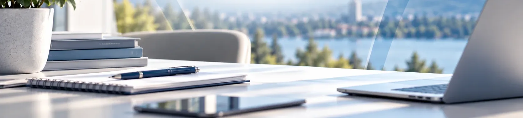 Espace de travail lumineux avec carnet, stylo et ordinateur portable devant une vue sur un lac